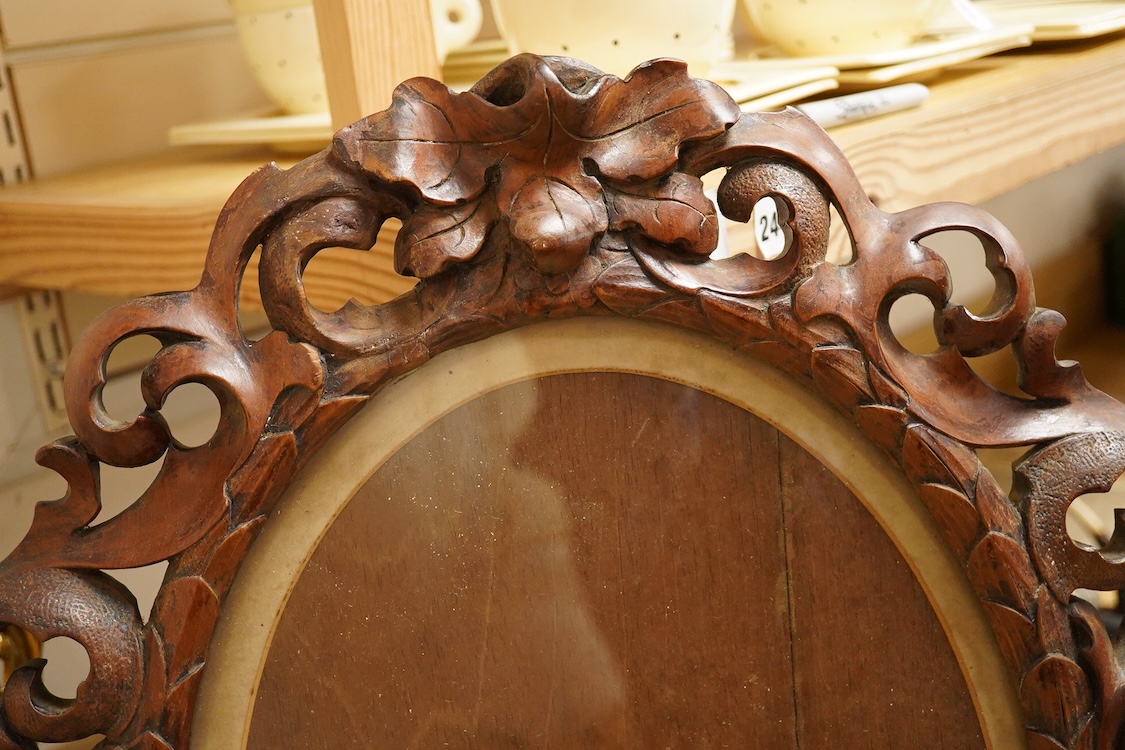 An oval carved wood mirror, 53cm high